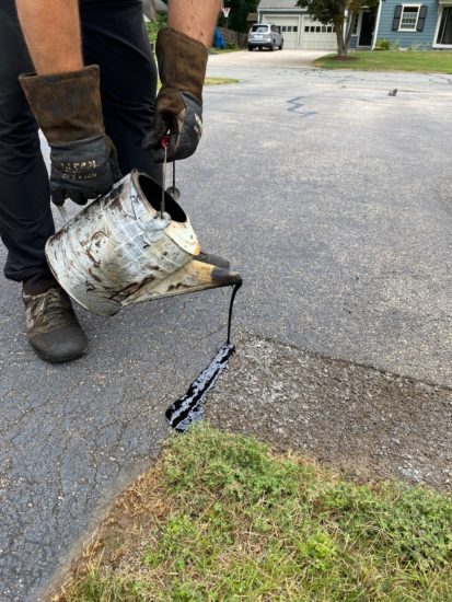 Worcester MA driveway cracks sealed using hot kettle rubber and home driveway sealcoated