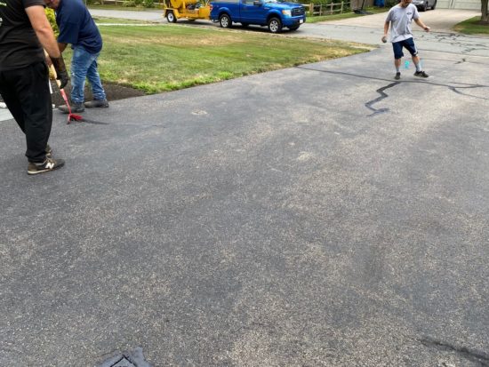 Worcester MA driveway cracks sealed using hot kettle rubber and home driveway sealcoated