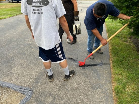 Worcester MA driveway cracks sealed using hot kettle rubber and home driveway sealcoated