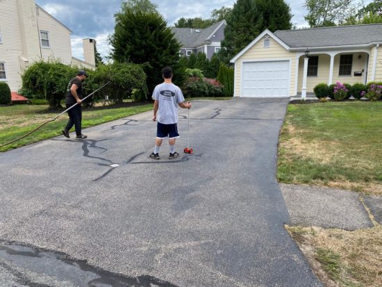 Worcester MA driveway cracks sealed using hot kettle rubber and home driveway sealcoated